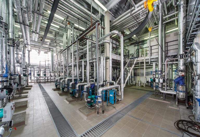 industrial boiler interior with lots of pipes, pumps and valves.